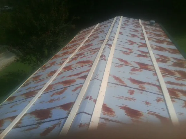 Rusted metal roof panels with new wood purlins before replacement — Storm Damage Roof Repair in Forest City by Roofing Brothers