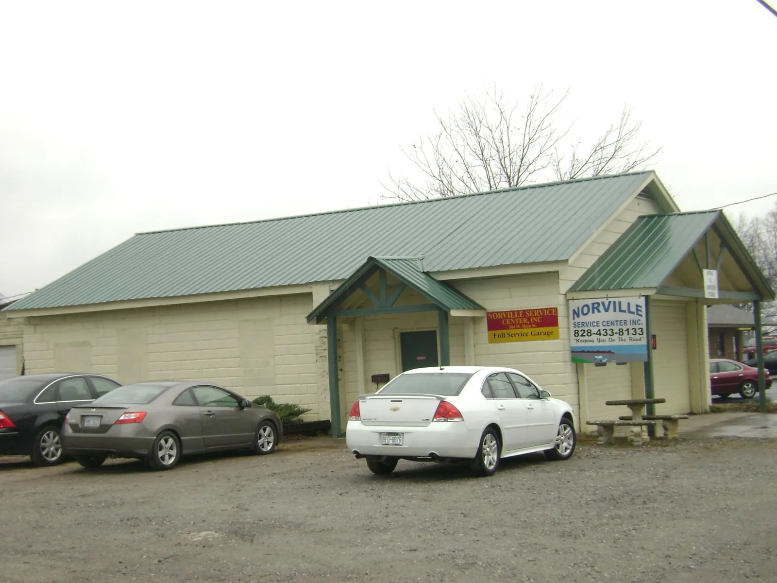 Green metal roof on a service garage with a covered entry in Forest City